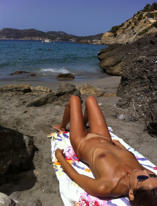 Обнаженная девушка загорает на берегу моря - секс порно фото